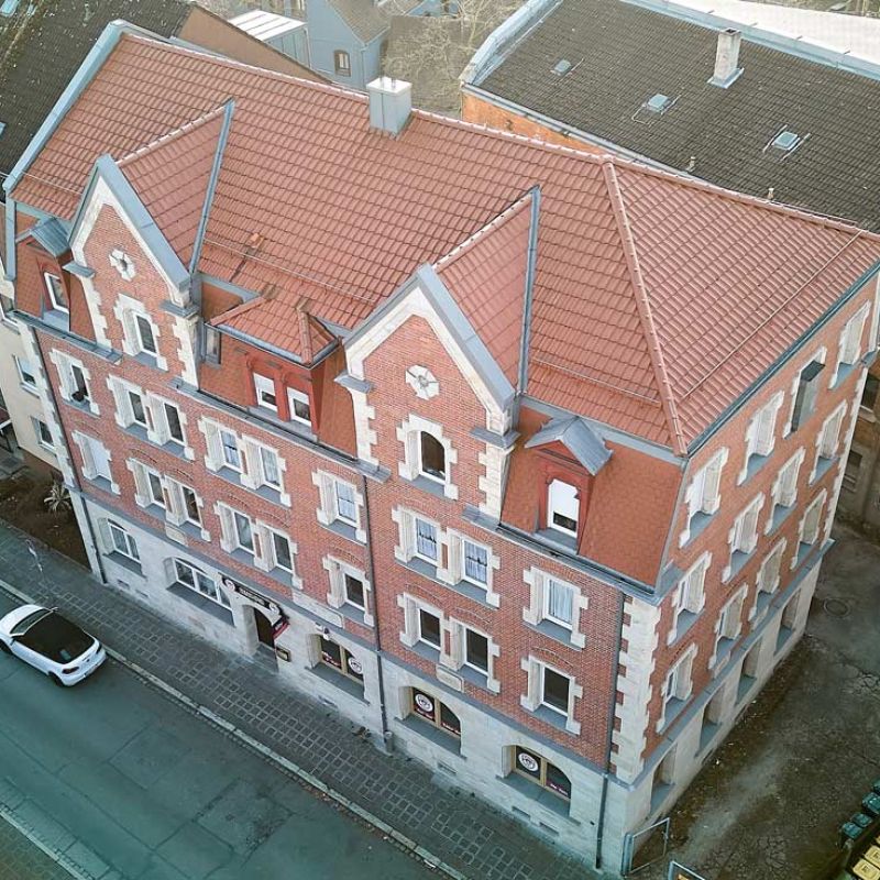 Kreuzsteinstraße 26, Nürnberg, mehrstöckiges Wohngebäude mit roter Fassade, Drohnenaufnahme seitlich