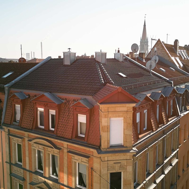 Dachansicht eines mehrstöckigen Sandsteingebäudes.