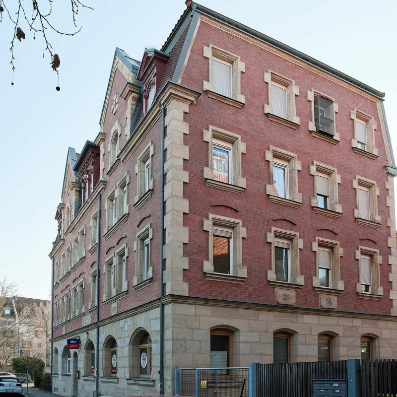 Kreuzsteinstraße 26, Nürnberg, mehrstöckiges Wohngebäude mit roter Fassade, seitlich